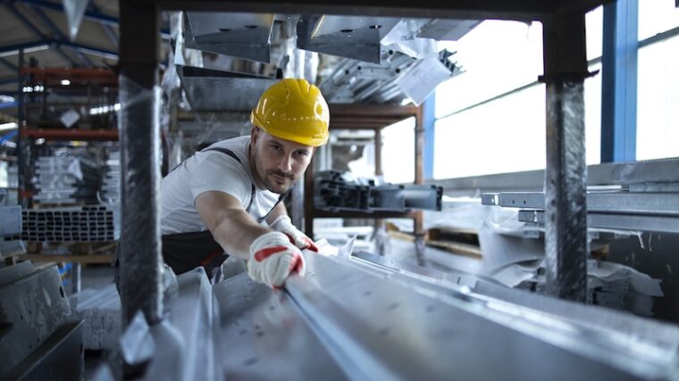 Industriarbetare som jobbar med plåt