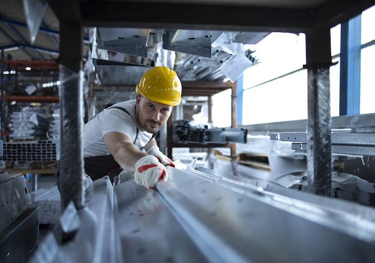 Industriarbetare som jobbar med plåt